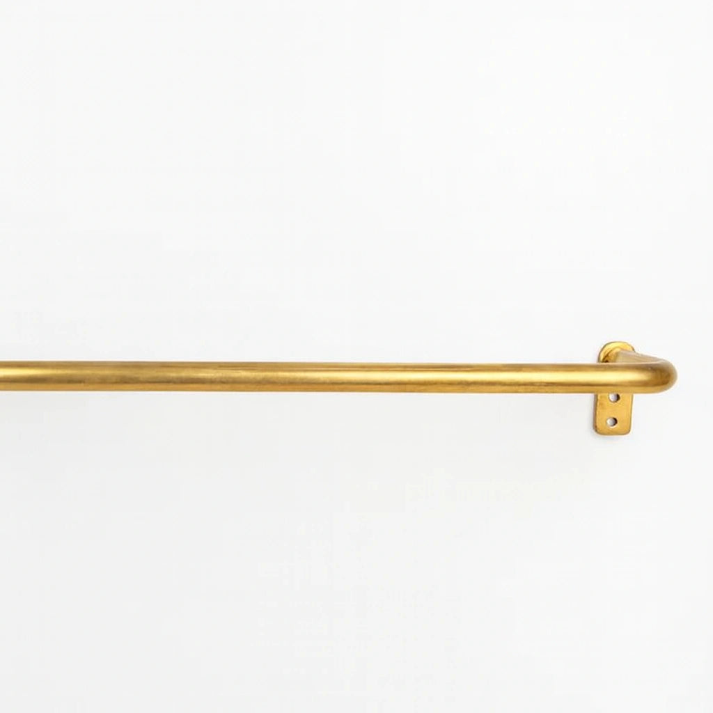 Unlacquered brass curtain rod on a clean white background showing natural patina and warm tone.