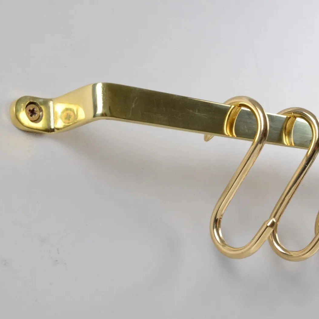 Close-up of flat unlacquered brass pot rack with mounted S-hooks – Atlas Finest