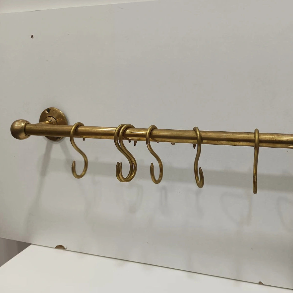 Unlacquered brass kitchen rod with S-hooks, wall-mounted design, perfect for hanging utensils and accessories – Atlas Finest premium handcrafted brass hardware