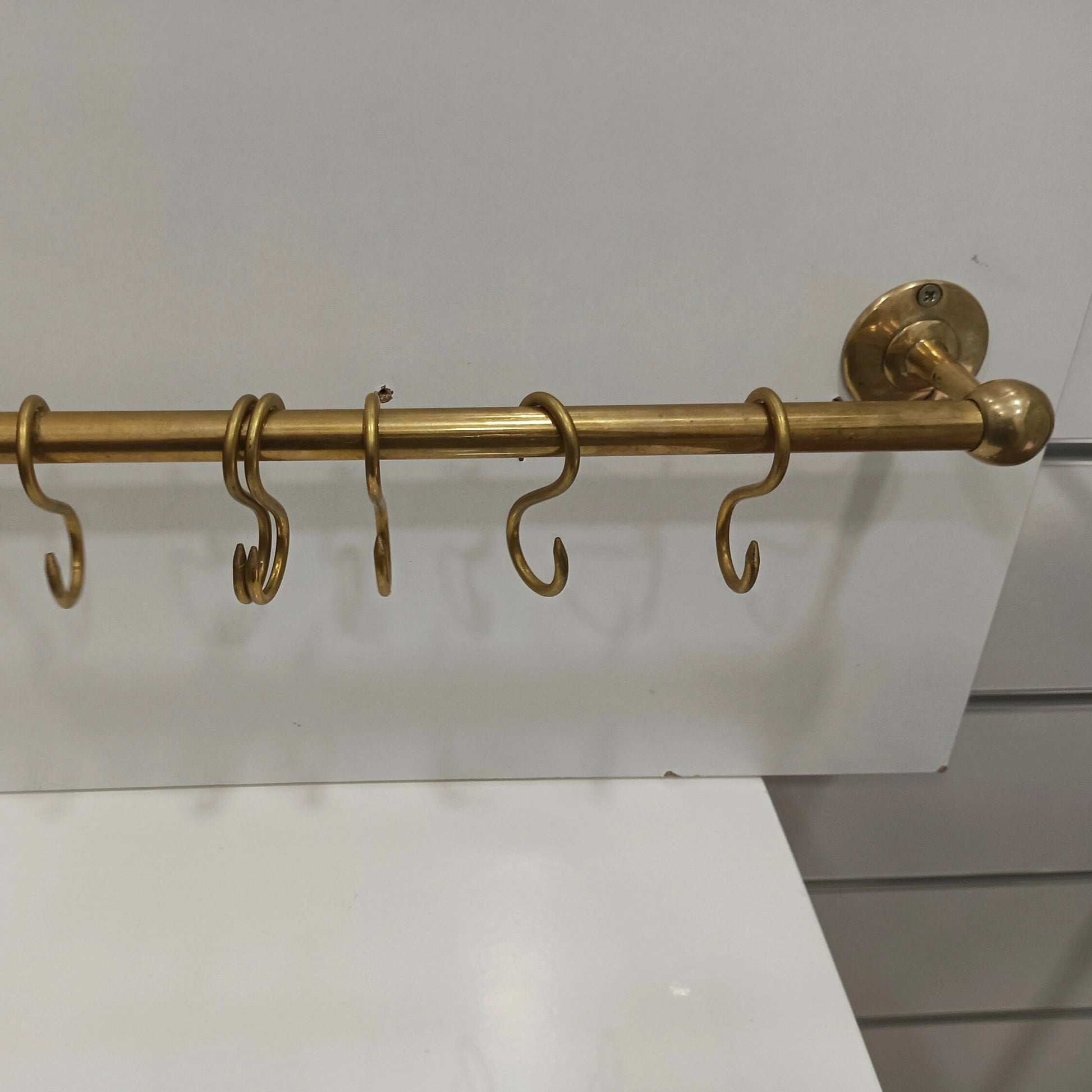 Premium unlacquered brass wall-mounted rod with S-hooks, perfect for organizing kitchen utensils and accessories – Atlas Finest handcrafted brass hardware