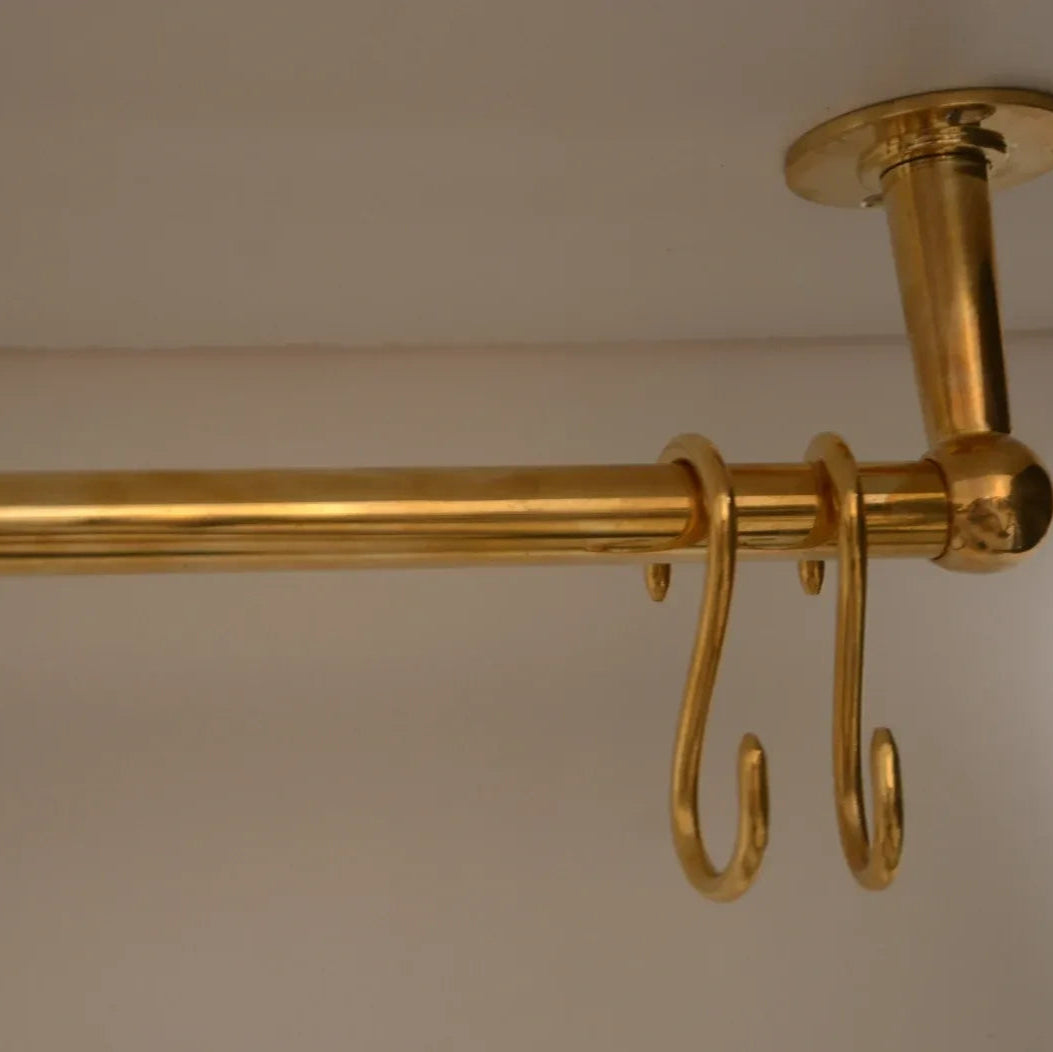 Close-up of ceiling-mounted unlacquered brass kitchen rod with S-hooks for storage – Atlas Finest