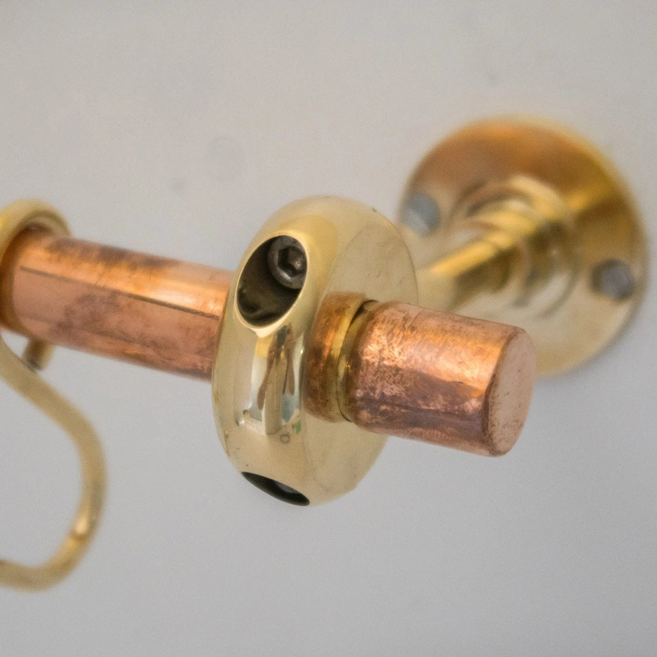 Close-up of unlacquered brass and copper wall-mounted kitchen rod bracket – Atlas Finest