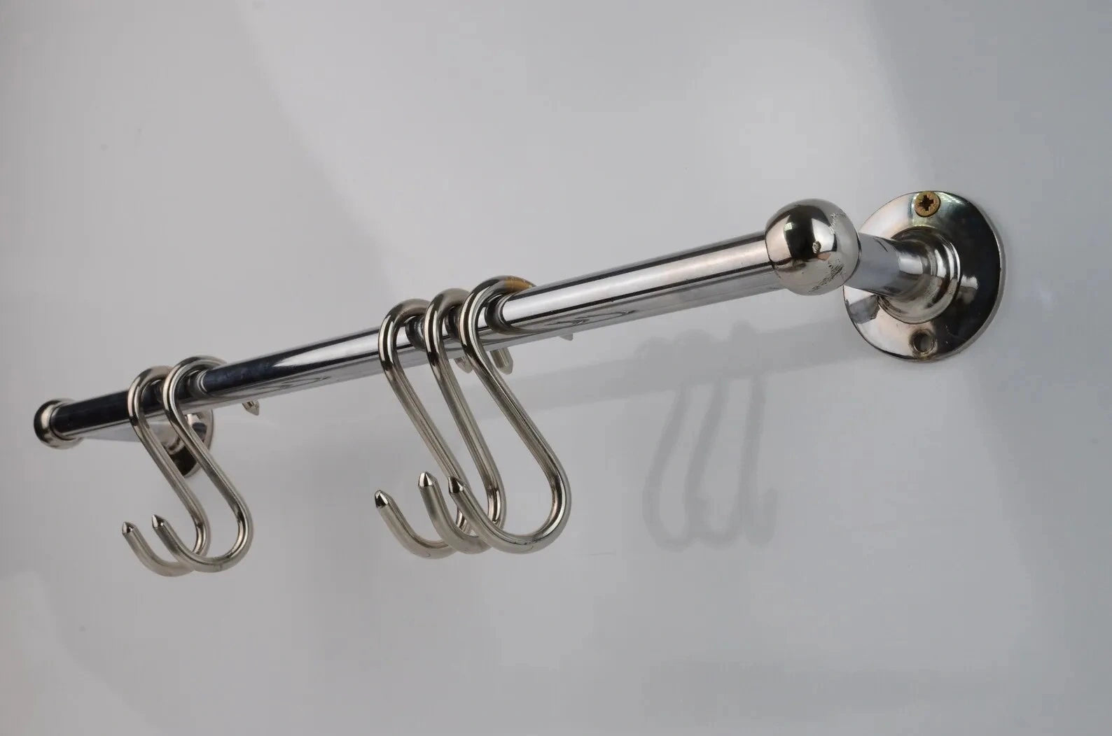 Polished chrome wall-mounted pot rail bar made from solid brass, featuring four S-hooks for kitchen utensil hanging and cookware display