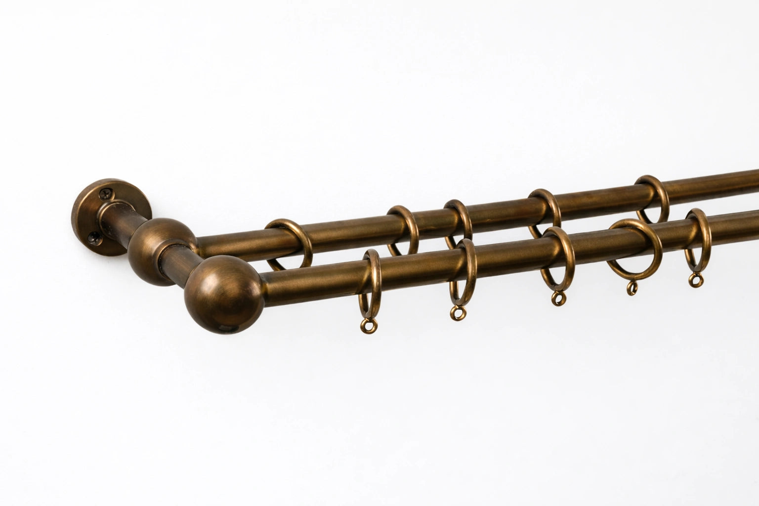 Brass curtain rod with spherical ends on a white background