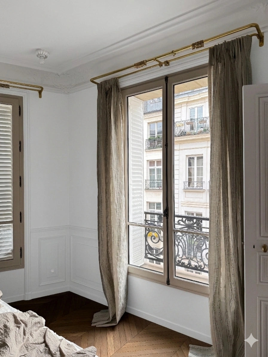 Room with large window and curtains, showing a building exterior.