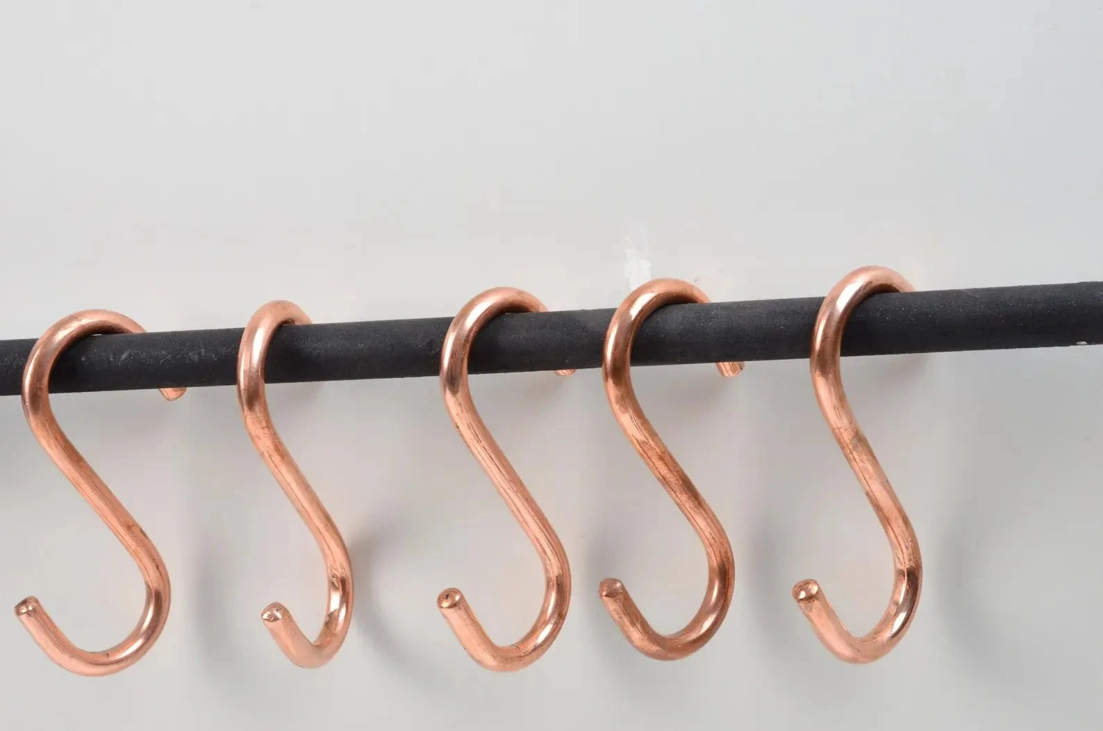 Durable black iron pot rail featuring copper S-hooks for efficient kitchen organization – Atlas Finest