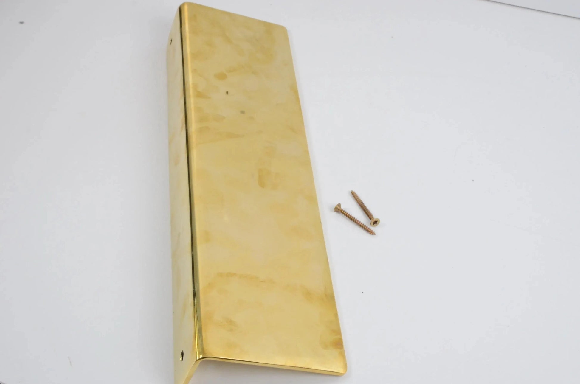 Long unlacquered brass floating shelf with installation screws on white background, showcasing polished golden finish and elegant craftsmanship-atlas finest