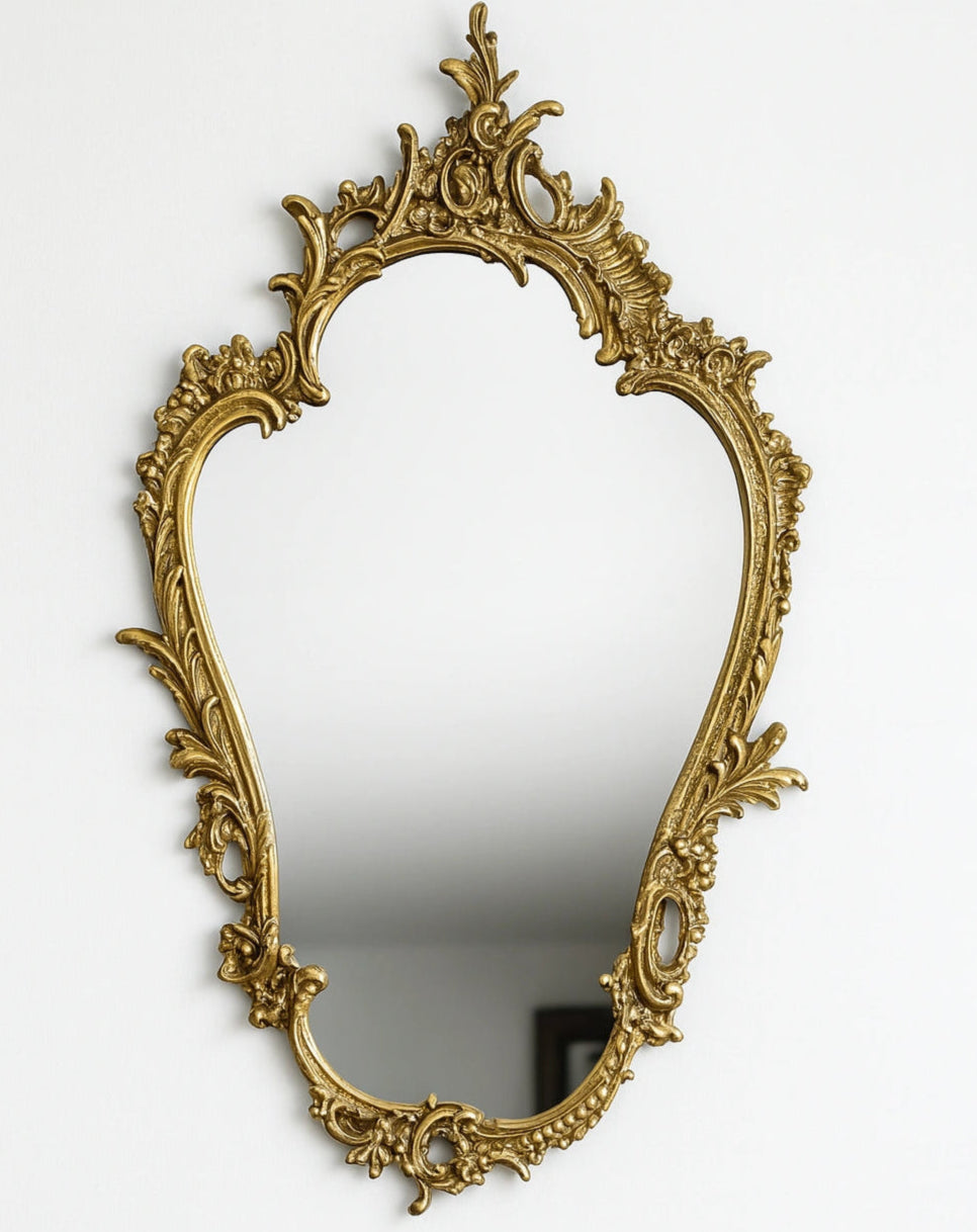 Elegant Victorian brass mirror with ornate craftsmanship, unlacquered brass frame, vintage wall-mounted decor
