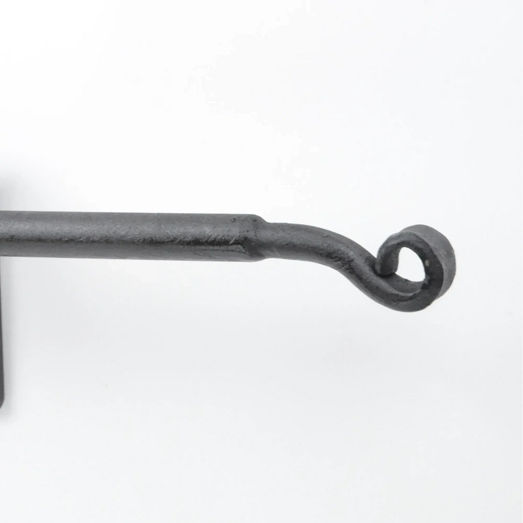 Black wrought iron curtain rod with wall-mounted bracket on white background