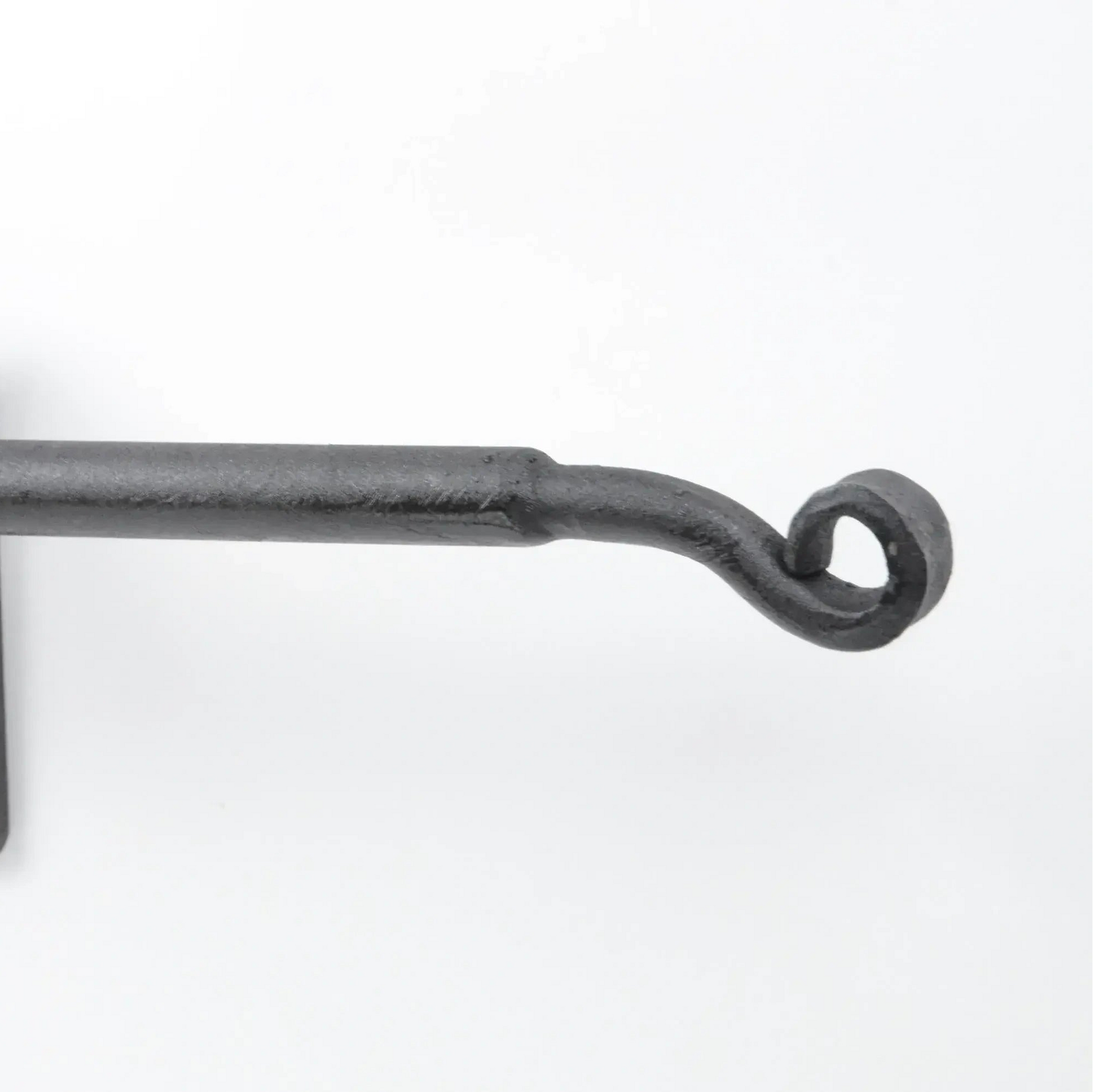 Black wrought iron curtain rod with wall-mounted bracket on white background