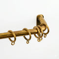 agedcurtain rod with rings on a white background
