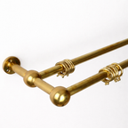 Gold curtain rods with decorative ball ends on a white background
