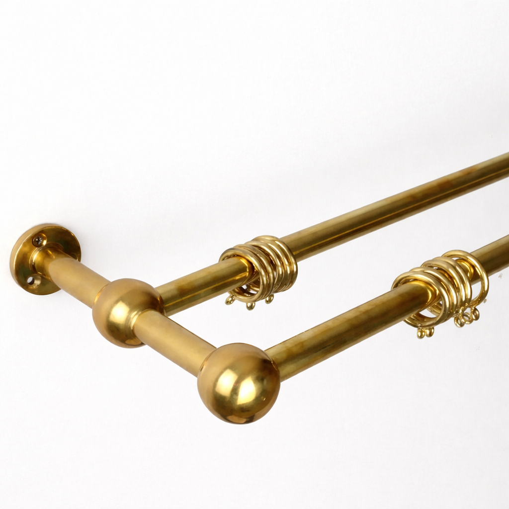 Gold curtain rods with decorative ball ends on a white background