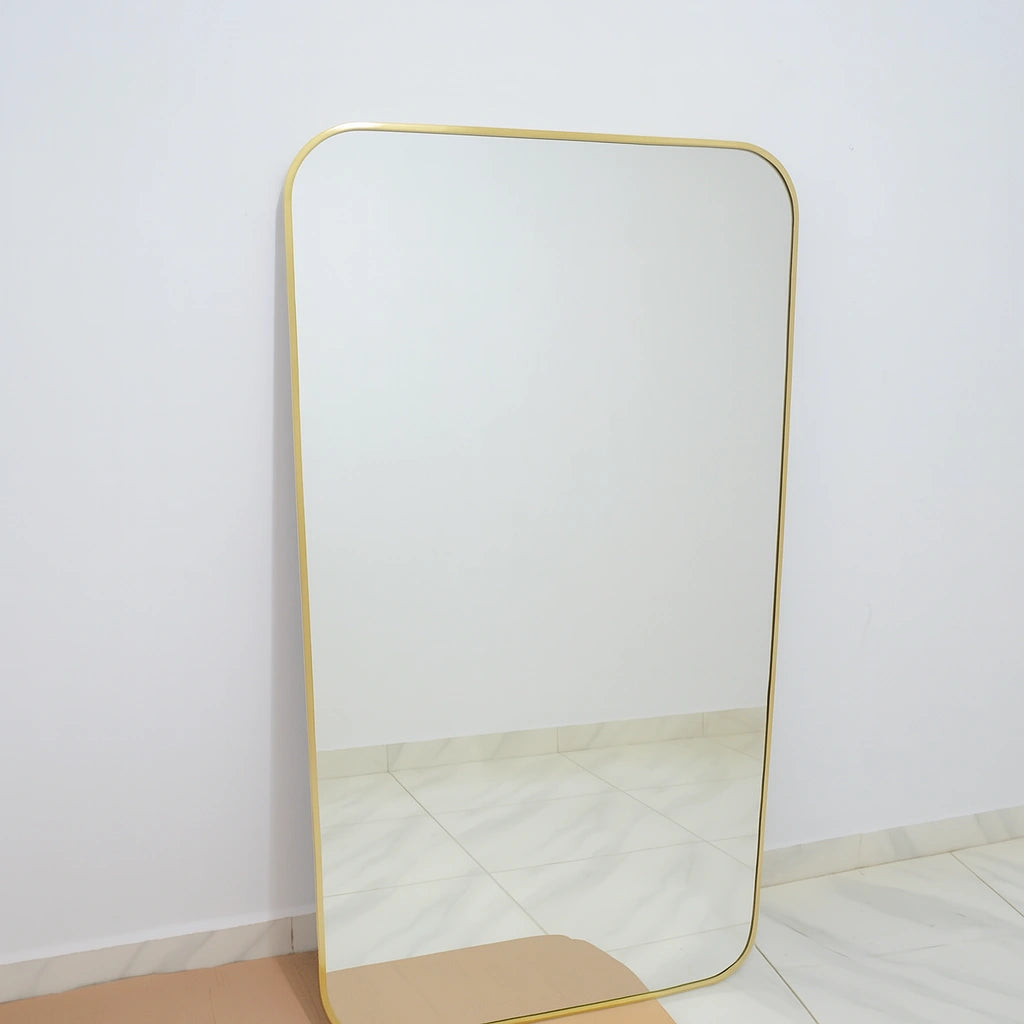 Minimalist brass full-length mirror with an unlacquered brass frame