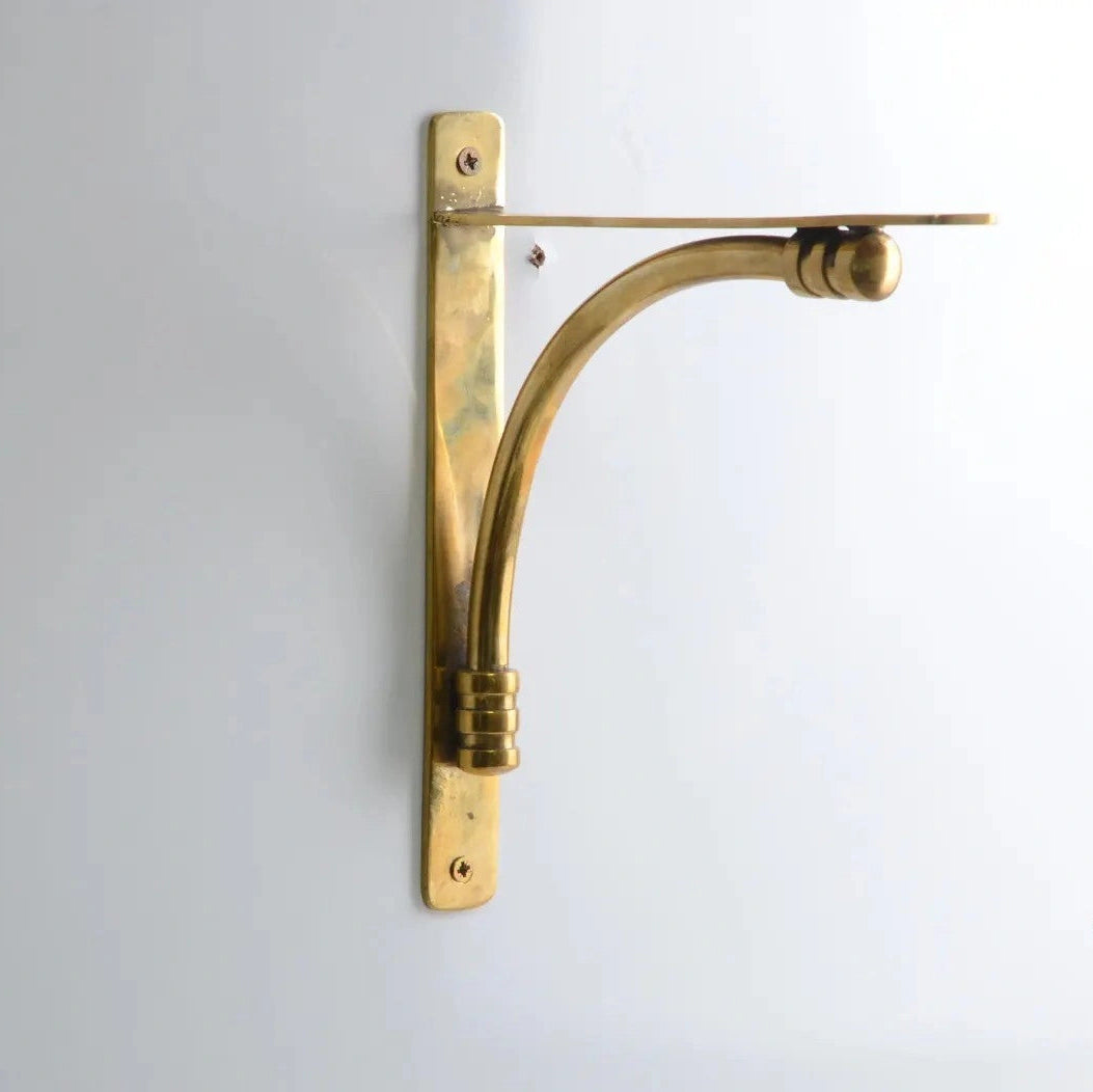 Minimalist brass shelf holder mounted on a clean white wall, perfect for modern kitchen or home décor